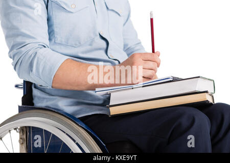 Mann im Rollstuhl mit Bücher Stockfoto