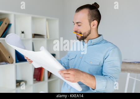 Architekten im Rollstuhl bei Blueprints suchen Stockfoto