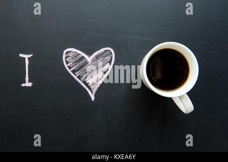 Blick von oben auf die Liebe Herz doodle Zeichnung auf Schiefertafel mit Tasse Kaffee Stockfoto