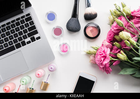 Flach mit verschiedenen Kosmetik, Blumenstrauß, Laptop und Smartphone auf Weiß isoliert Stockfoto