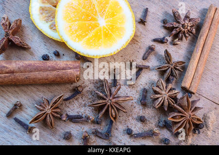 Sternanis, orange frut Scheiben, Zimt und Nelken auf hölzernen Tisch. Selektive konzentrieren. Stockfoto