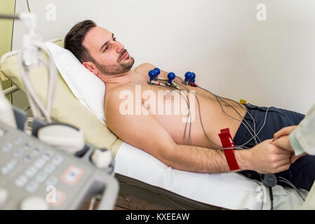 Junger Mann tun präventiven EKG im Krankenhaus Stockfoto