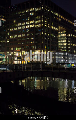 Bürogebäude mit erleuchteten Fenstern in Canary Wharf Financial District in der Nacht, Docklands, London, England, Großbritannien Stockfoto