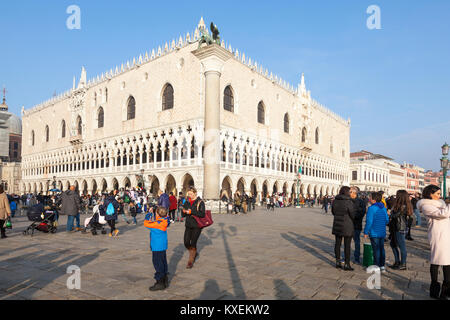 Junge fotografieren der Herzogliche Palast, Dogenpalast, Palazzo Ducale, Venedig, Venetien, Italien in warmes Abendlicht im Winter unter anderem Touristen Stockfoto