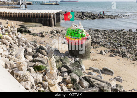 Bemalte Skulpturen aus Stein am Strand entlang der Uferpromenade am Ribeira das Naus, Lissabon, Portugal Stockfoto