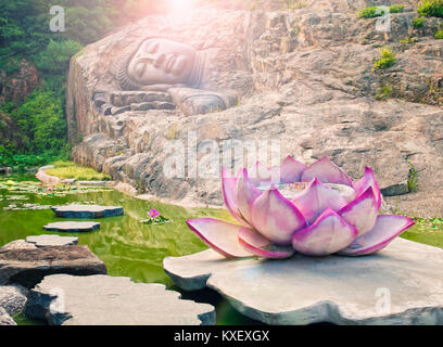 Warmen verarbeitete Bild der Statue des schlafenden Buddha in Rock im Lotus Teich im Tempel mit Lotus geformte Management-standards stand bei Sonnenuntergang geschnitzt Stockfoto
