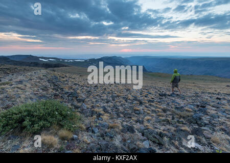 Ein Mann schaut die Sonne hinter Wolken von oben von Steens Mountain, North Carolina. Stockfoto