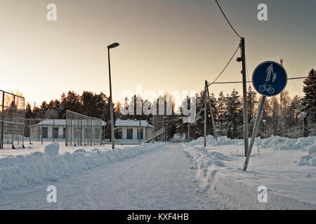 Einen verschneiten Fußweg führt zu der ländlichen Stadt Oulainen im Norden Finnlands. Der Frost hat gerade über alles, das durch den Pfad abgedeckt. Stockfoto