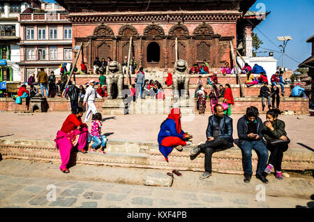 Einige gemütliche Nepalesen Aalen in der Wintersonne, Kathmandu Durbar Square, Nepal Stockfoto