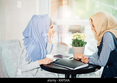 Porträt von zwei Frau sprechen beim Sitzen auf der Couch Kaffee genießen. Stockfoto