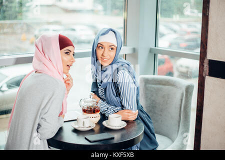 Porträt von zwei Frau sprechen beim Sitzen auf der Couch Kaffee genießen. Stockfoto