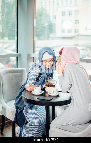 Porträt von zwei Frau sprechen beim Sitzen auf der Couch Kaffee genießen. Stockfoto