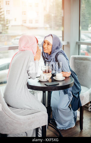 Porträt von zwei Frau sprechen beim Sitzen auf der Couch Kaffee genießen. Stockfoto