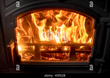 Brennholz auf Feuer gesehen, durch die Fenster von einem Herd, auf dem Land Details im Innenraum Stockfoto