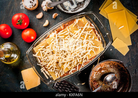 Kochen hausgemachte klassische Lasagne Bolognese, auf dunkelblauem Tabelle; mit Zutaten, Ansicht von oben kopieren Raum Stockfoto