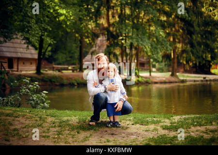 Rot - Heared Vater und rot-Heared Sohn Spaß haben in einem Park in einer traditionellen weißen Hemden mit Ornament Stockfoto