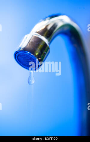 Ein Bach mit sauberem Wasser fließt in das Waschbecken aus Edelstahl in blau Tönen. Waschbecken aus Edelstahl Öffnung schließen oben mit Wasser Stockfoto