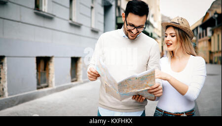 Glückliche Touristen Sehenswürdigkeiten Stadt mit Karte Stockfoto