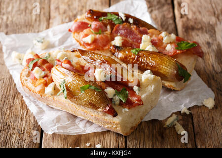 Sandwiches mit karamelisierten Schalotten, Speck und Roquefort Käse close-up auf dem Tisch. Horizontale Stockfoto