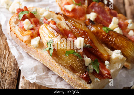 Sandwiches mit karamelisierten Schalotten, Speck und Roquefort Käse Makro auf dem Tisch. Horizontale Stockfoto