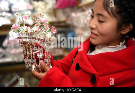 Rongjiang, Chinas Provinz Guizhou. 9 Jan, 2018. Ein Kunde wählt Silber Schmuck in einem Geschäft in Guzhou Township von Rongjiang County, im Südwesten Chinas Provinz Guizhou, Jan. 9, 2018. Die lokale Bevölkerung der ethnischen Minderheiten bereit, die Silber Schmuck den kommenden Frühling Festival, das am 13.02.16 In diesem Jahr fällt, zu begrüßen. Credit: Wang Bingzhen/Xinhua/Alamy leben Nachrichten Stockfoto