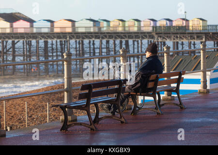 Hastings, East Sussex, UK. 10. Januar 2018. Einen hellen und sonnigen Start in den Tag in Hastings mit vielen Menschen heraus und über die Vorteile der ungewöhnlich warmen Wetter. Dieser Mann sitzt auf einem der Promenade Bänke, die in der Ansicht angezeigt. Foto: Paul Lawrenson/Alamy leben Nachrichten Stockfoto