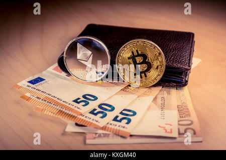 Finanzkonzept mit physischen Bitcoin und des Astraleums über eine Brieftasche mit Euro Rechnungen Stockfoto