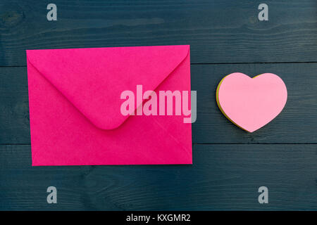 Liebesbrief in rosa Umschlag mit Liebe Herz Form auf Holz Tisch Stockfoto