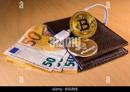 Finanzkonzept mit physischen Bitcoin und des Astraleums über eine Brieftasche mit Euro Rechnungen Stockfoto