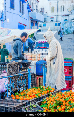 Chefchaouen, Marokko - 8. Dezember: Mann Kommissionierung Orangen auf dem lokalen Markt in Lima. Dezember 2016 Stockfoto