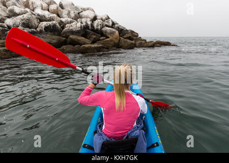 Eine Frau Kajaks entlang der breakwall in Marina Del Rey, Kalifornien. Stockfoto