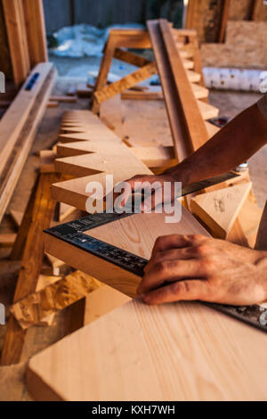 A bemannt Hände arbeiten mit einem Platz auf dem Schlitten für eine Treppe in einem Haus im Bau. Stockfoto