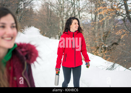 Mädchen auf einer Wanderung auf verschneiten Bergweg Stockfoto