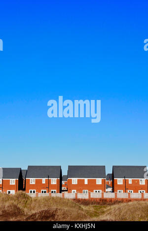 Reihe von gleichen Neubau Einfamilienhäuser unter einem grossen blauen Himmel in St Annes, Lancashire, Großbritannien Stockfoto