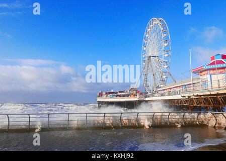 Wellen, die über die ufermauer vor dem Riesenrad auf Central Pier bei Unwetter Stockfoto