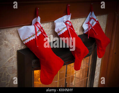 Drei rote Weihnachten Strümpfe an den Kamin mit Zuckerstangen Stockfoto