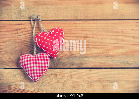 Zwei Herzen auf rotem Stoff alte Holz Hintergrund, vintage Prozess Stockfoto