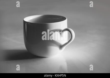 Herzförmige Schatten auf eine Tasse Kaffee, Schwarz und Weiß Stockfoto