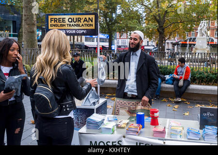 Muslimische bietet eine kostenlose Kopie des Koran auf die London Street Stockfoto