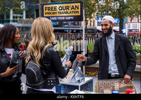 Muslimische bietet eine kostenlose Kopie des Koran auf die London Street Stockfoto