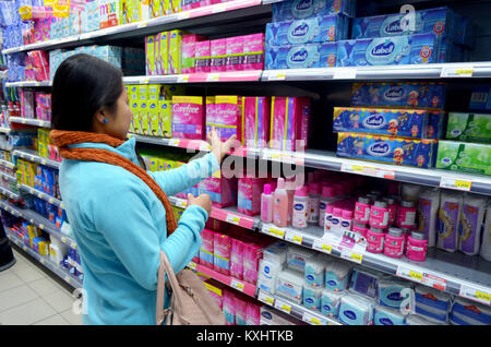 Portugal, Algarve, Tavira, ca. 10 Dezember. 2013. Junge Frau Einkauf Sanitär Produkte aus einem Supermarkt. Bild aufgenommen am 10 Decembe Stockfoto