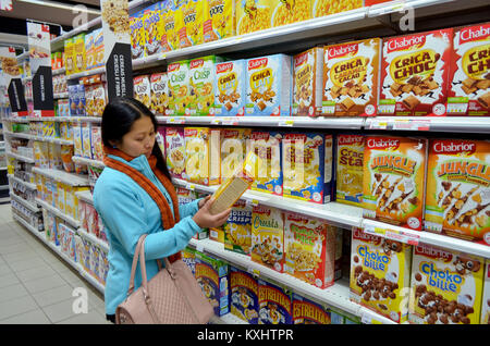 Portugal, Algarve, Tavira, ca. vom 10. Dezember 2013. Junge Frau Wahl Getreide in einem Supermarkt. Stockfoto