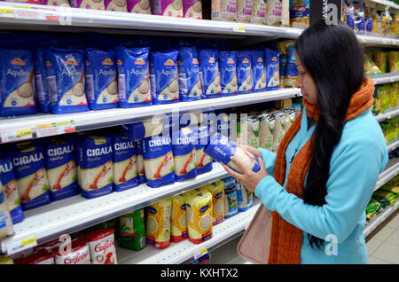 Portugal, Algarve, Tavira, ca. vom 10. Dezember 2013. Junge Frau im Supermarkt kaufen, ein Paket von Reis. Stockfoto