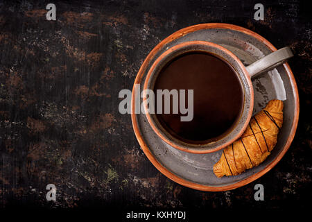 Tasse duftenden Kaffee und ein Croissant. Frühstück am Morgen. Flach. Ansicht von oben Stockfoto