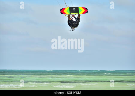 Ein kitesurfer Durchführen einer Antenne trick Reiten trägerlosen Surfboard an einem sonnigen Tag. Professionelle Kiter macht das schwieriger Trick. Stockfoto