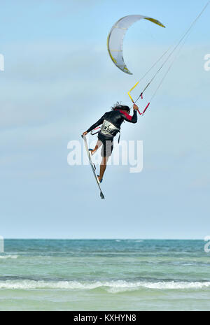 Ein kitesurfer Durchführen einer Antenne trick Reiten trägerlosen Surfboard an einem sonnigen Tag. Professionelle Kiter macht das schwieriger Trick. Stockfoto