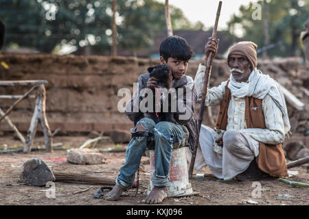 Ein Junge mit seinem Hund und grossvater am Nachmittag Licht in Madhya Pradesh in Indien. Stockfoto