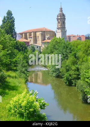 Dieses Foto zeigt den Fluss Ibaizábal, der durch Amorebieta-Etxano im Baskenland fließt, mit der Kirche Santa María de la Asunción in der Nähe. Das Bild zeigt die Landschaft, Architektur und natürliche Umgebung der Stadt. Stockfoto