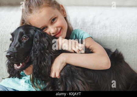Porträt eines lächelnden Mädchen umarmen Hund zu Hause Stockfoto