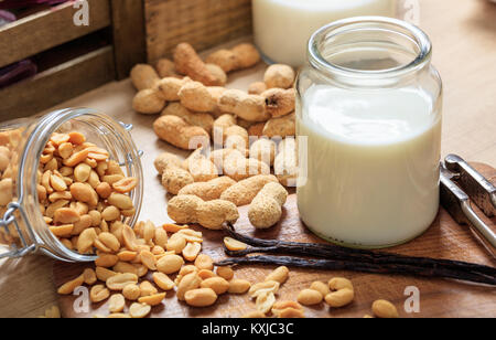 Vegan Milch aus Erdnüssen auf einer hölzernen Oberfläche Stockfoto